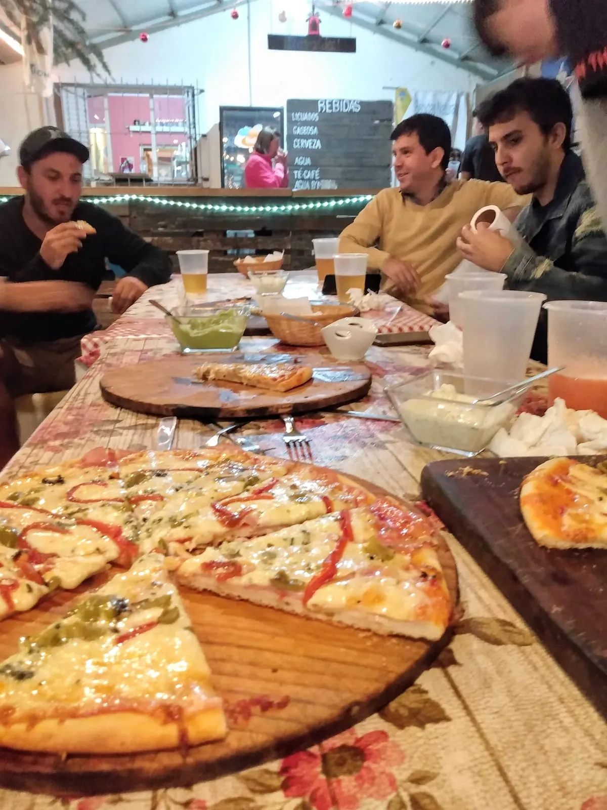 Grupo de amigos compartiendo pizzas en una noche de verano